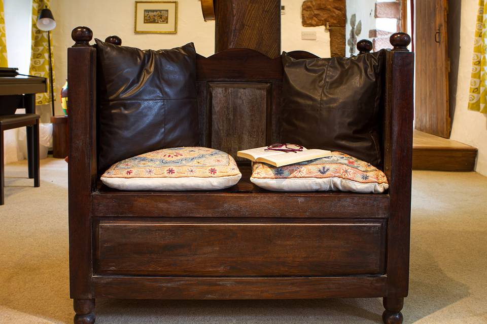 Old wooden two-seater bench with colourful cushions