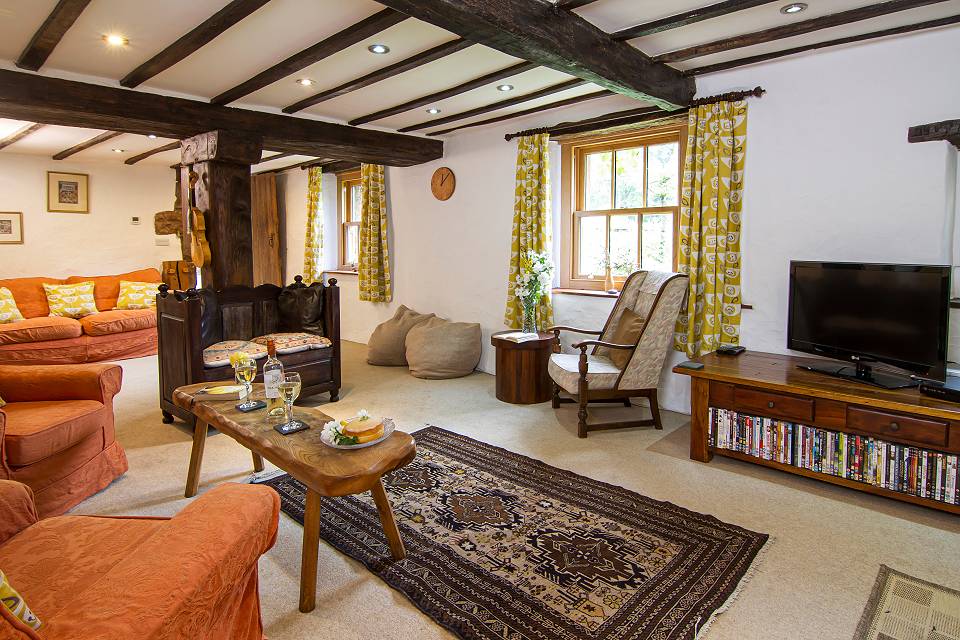 Wide angle shot of the lounge with oak beans on the ceiling, a drinks table, chairs and beanbags