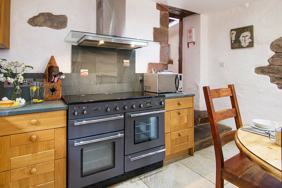 Double oven and hob in the kitchen with modern extraction fan and microwave
