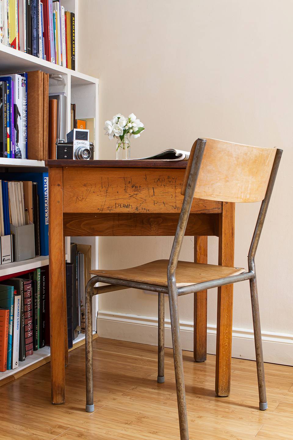 A small table and chair next to a bookcase