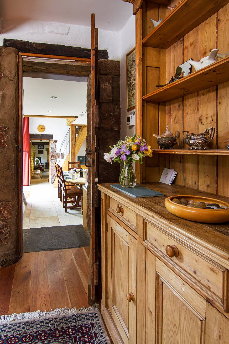 Hallway with wooden dresser looking through an open door into the kitchen