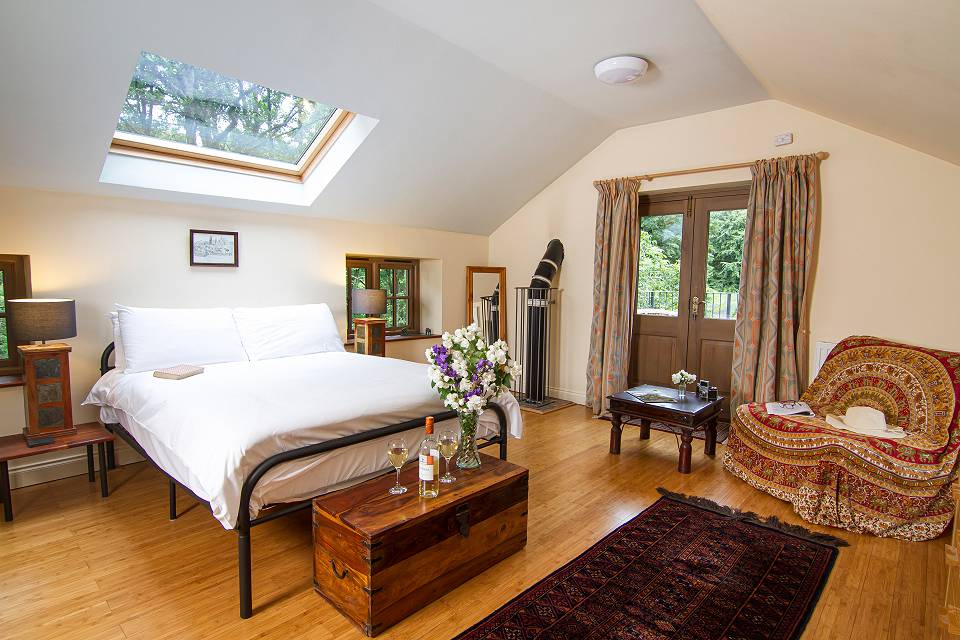 A modern attic bedroom with wooden floor