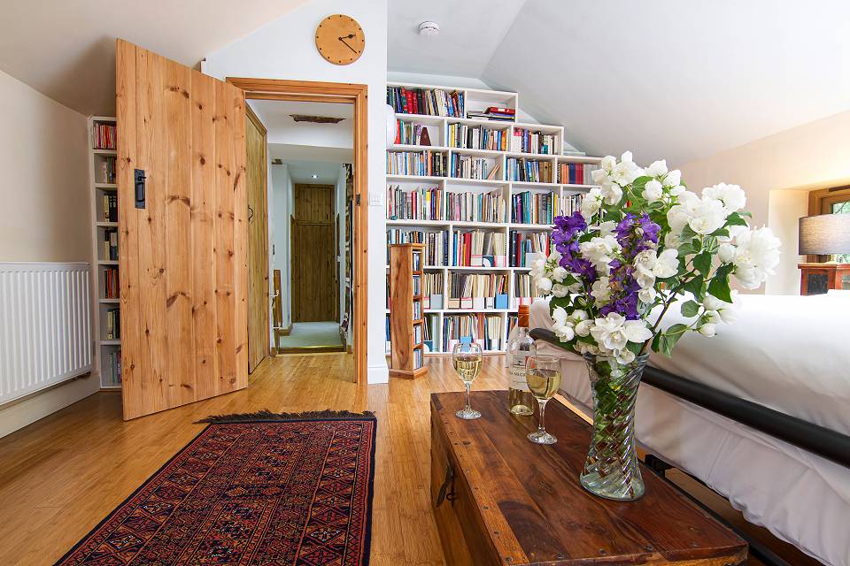 Looking to wards a bookcase full of books and an open door into the hallway