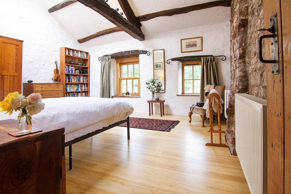 Bedroom with wooden floor and exposed oak beams