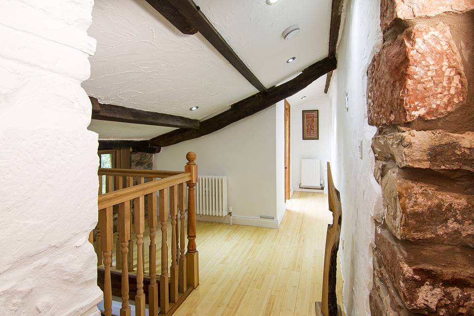 Landing with exposed stone, plastered walls and exposed oak beams
